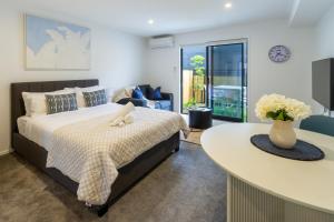 a bedroom with a bed and a table at Modern Studio Near Stadium, Dining & City Fun in Christchurch