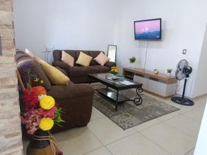 a living room with a couch and a coffee table at Beautiful and cozy home with Rent a car available in San Salvador