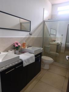 a bathroom with a sink and a toilet and a mirror at Beautiful and cozy home with Rent a car available in San Salvador