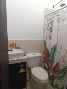 a bathroom with a toilet and a sink at Beautiful and cozy home with Rent a car available in San Salvador +10 photos