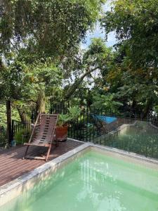 einen Stuhl auf einer Terrasse neben einem Pool in der Unterkunft Santa Teresa Junto à Natureza in Rio de Janeiro