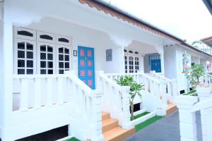a white house with blue doors and stairs at Vagary Pangkor in Pangkor