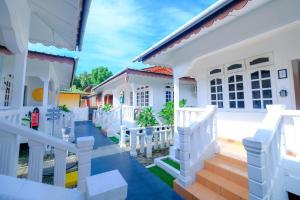 a white house with a white fence and stairs at Vagary Pangkor in Pangkor +19 photos