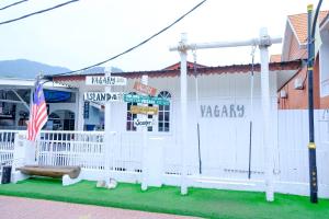 a white building with an american flag in front of it at Vagary Pangkor in Pangkor