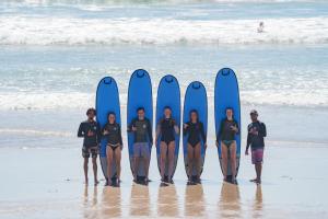 サンタ・テレサにあるLa Posada - Hostelの海岸に立ちサーフボードを持つ人々
