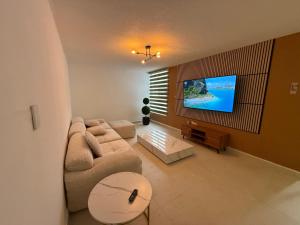 ein Wohnzimmer mit Sofa und Flachbildfernseher in der Unterkunft SextoMaíz in Morelia