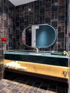 a bathroom sink with a large mirror on the wall at Umi Resort 菩提有米 in Sihanoukville