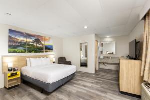 a hotel room with a bed and a television at Days Inn by Wyndham Wheatland in Wheatland