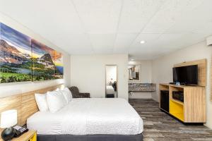 a hotel room with a bed and a flat screen tv at Days Inn by Wyndham Wheatland in Wheatland