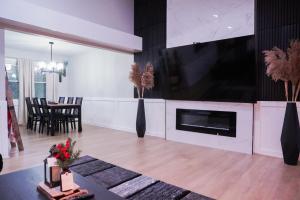 Jacuzzi Cul de Sac Home في Country Club Hills: غرفة معيشة مع تلفزيون بشاشة مسطحة كبيرة