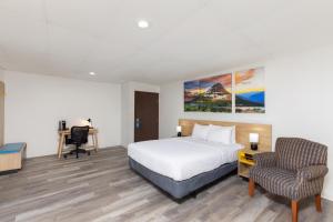 a hotel room with a bed and a desk and a chair at Days Inn by Wyndham Wheatland in Wheatland