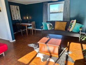 a living room with a couch and a table at Dark Sky Cottage in Greytown