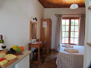 a bedroom with a bed and a table with a bowl of food at Spiti Melianou in Agios Georgios Pagon