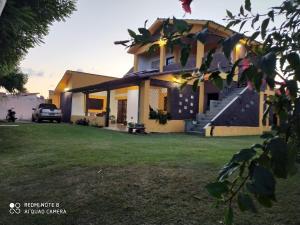 a house with a lawn in front of it at Pé na Terra - Suítes in São Miguel do Gostoso