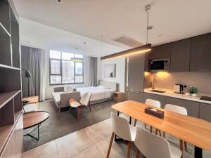 a hotel room with a bed and a table and chairs at LN Residence Changdi New Aiqun Building in Guangzhou