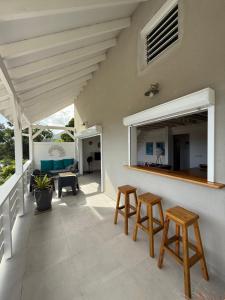 a patio with two stools and a counter on a house at Appartement neuf a 150 metres de la mer wifi in Le Diamant