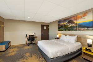 a hotel room with a bed and a desk at Days Inn by Wyndham Wheatland in Wheatland