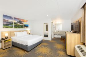 a hotel room with a bed and a television at Days Inn by Wyndham Wheatland in Wheatland +12 photos