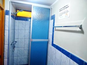 a bathroom with a shower with a blue door at Andes Hostel in Huaraz +65 photos