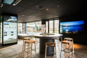 a bar with stools in a room with windows at Lake Shikotsu Tsuruga Resort Spa Mizu no Uta in Chitose