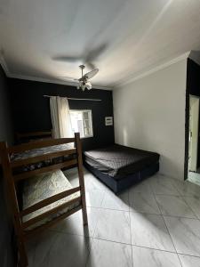 Un dormitorio con dos literas y un ventilador de techo. en Casa 140, en Guarujá