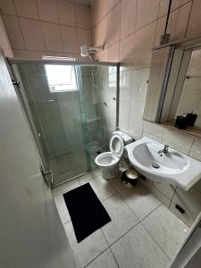Un baño con ducha, inodoro y lavabo. en Casa 140, en Guarujá 10 fotos más