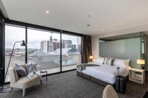 ホーソンにあるMainStay Suites Hawthornのベッドと大きな窓があるホテルの部屋