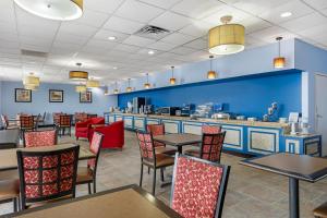 Baymont by Wyndham Richmond KY في ريتشموند: غرفة طعام مع طاولات وكراسي وبار