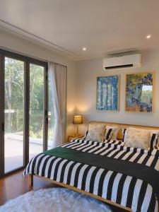 a bedroom with a bed and a large window at Golden Andes 豪华度假别墅 in Ban Mut Dok Khao