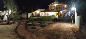 a house at night with a garden in front at Pé na Terra - Suítes in São Miguel do Gostoso +9 photos