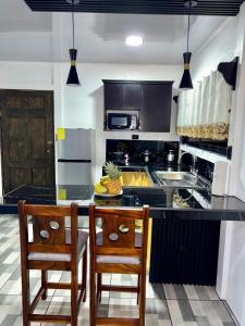 a kitchen with a counter with two chairs and a island at Casa de las aves in Guayabal +10 photos