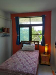 a bedroom with a bed in front of a window at Open Mind Center Villas in Ban Tha Pai