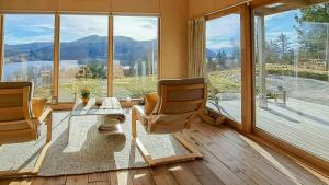 a living room with chairs and a table and a large window at Self-Built Cabin With Views Over Leirvik in Leirvik +12 photos