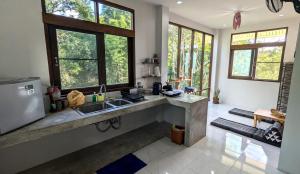 a kitchen with a sink and a counter with windows at Open Mind Center Villas in Ban Tha Pai