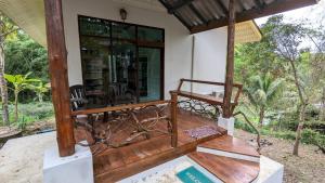 a porch of a house with a bed and chairs at Open Mind Center Villas in Ban Tha Pai +20 photos