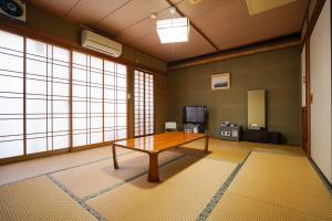 Habitación con mesa en una habitación con ventanas en Ryokan Kintoki, en Aso