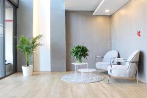 バンコクにあるUTD8 Hotel and Residenceの椅子2脚とテーブル1台のある待合室