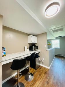Cozy Small Room - Queen bed - Free Parking in Charlottetown في شارلوت تاون: مطبخ مع كونتر وشرفتين من البار