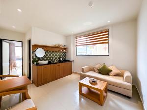 ein Wohnzimmer mit Sofa und Tisch in der Unterkunft Sujet Center Hotel by Haviland in Đà Nẵng