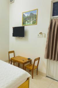 a room with a table and a tv on the wall at Tấn Đạt Hotel Quy Nhơn in Quy Nhon +20 photos