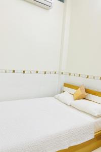a bedroom with a bed with white sheets and a window at Tấn Đạt Hotel Quy Nhơn in Quy Nhon