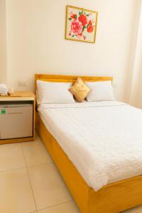 a bedroom with a bed with a wooden frame at Tấn Đạt Hotel Quy Nhơn in Quy Nhon