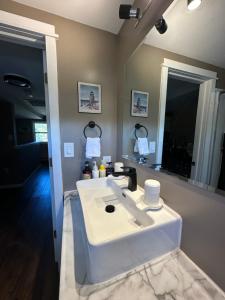 Cozy Small Room - Queen bed - Free Parking in Charlottetown في شارلوت تاون: حمام مع حوض أبيض ومرآة