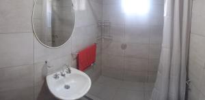 Colonia ChapadmalalにあるSal y Arenaの洗面台と鏡のある白いバスルーム