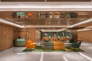 a lobby with chairs and tables in a building at Orange Hotel Beijing Xi'erqi in Beijing