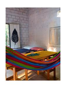 a hammock with a table and a bed in a room at Casa Segredo da Mata in Alter do Chao