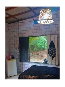 a room with a window and a bed and a light at Casa Segredo da Mata in Alter do Chao