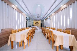 a row of tables and chairs in a room with windows at Seoul Hotel Cat Ba in Cat Ba