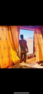 a man standing in front of a window in the desert at Rayyan Bedouin life camp in Wadi Rum