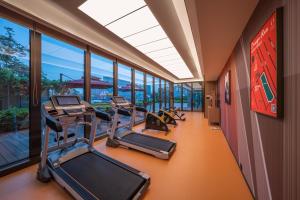 a gym with treadmills and ellipticals in a building at Orange Hotel Beijing Xi'erqi in Beijing
